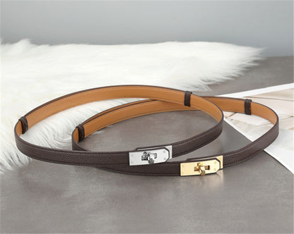 Two Etoupe Epsom leather Kelli belts, one with golden hardware and one with silver hardware, showcasing the versatile grey-brown tone