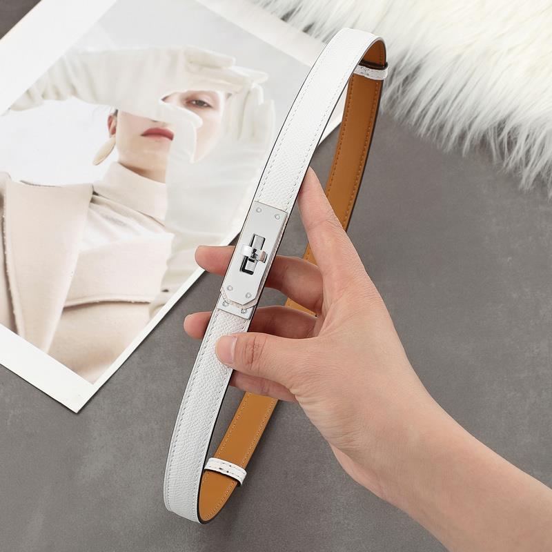 A sleek white Epsom leather Kelli belt featuring a polished silver-tone turn-lock plate and tan leather lining