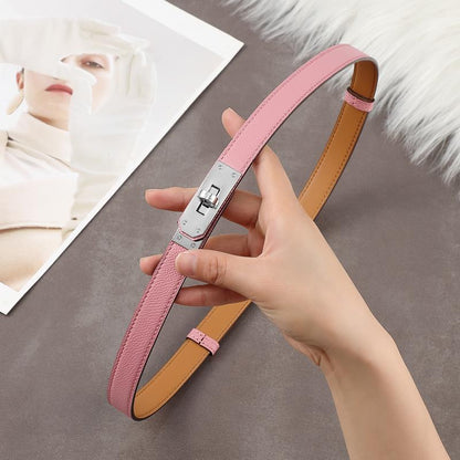 A soft pink Epsom leather Kelli belt featuring a polished silver-tone turn-lock plate and tan leather lining.