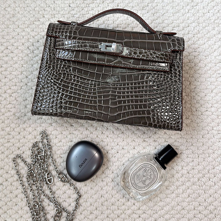Grey crocodile embossed leather Kelli clutch bag with silver chain strap and everyday essentials.