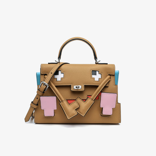 Front view of the Inspired Kelly Doll Picto Quelle Idole handbag in brown Epsom leather, featuring a whimsical mosaic face design with pink leather accents and a silver turn-lock.