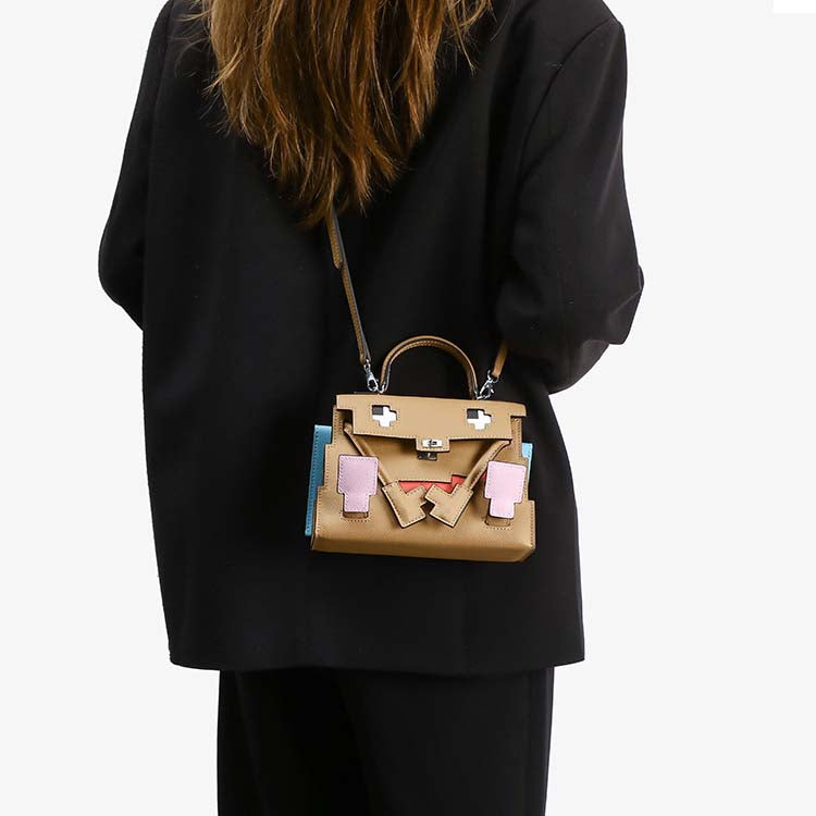 Mini Picto Kelli Doll bag in tan Epsom leather with pixelated face design, top handle, and adjustable crossbody strap.