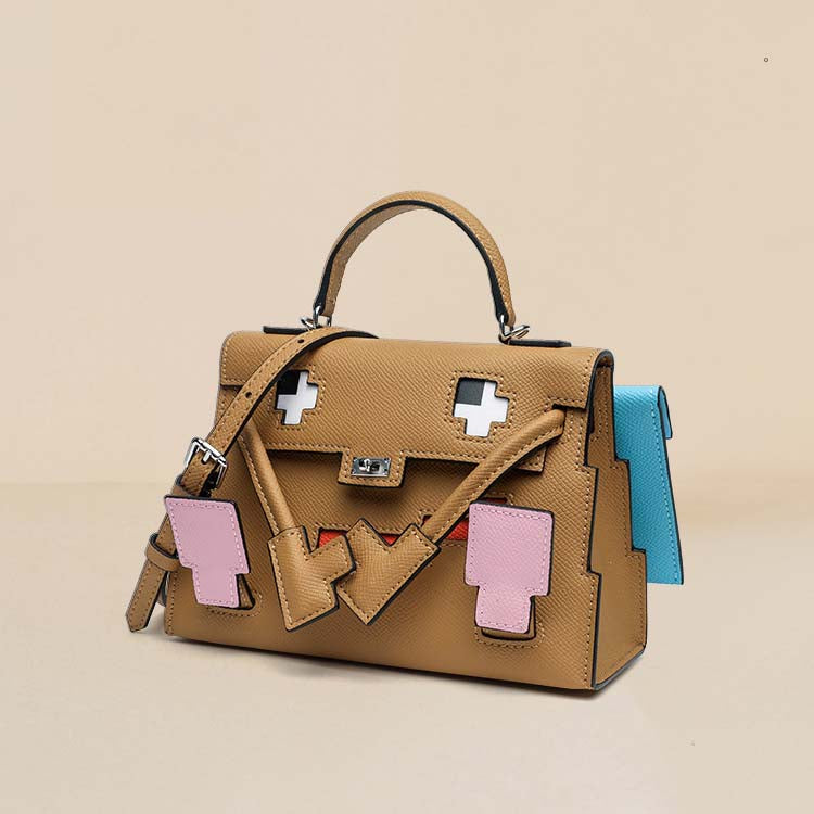 An interior view of the Chai Leather Picto Kelly Doll bag, showcasing its spacious interior, swivel clasp details, and playful arm-shaped top handle.