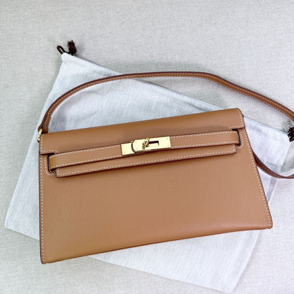 Gold brown split leather inspired Kelly Elan shoulder bag with gold hardware and shoulder strap on a white dust bag.