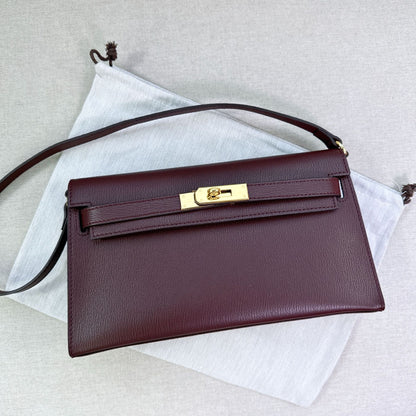 Wine split leather inspired Kelly Elan shoulder bag with golden hardware on a white dust bag.