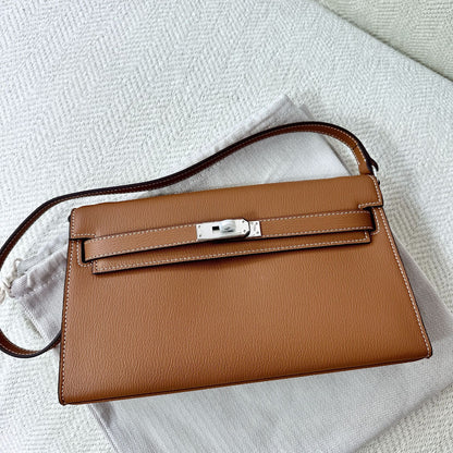 Gold brown split leather inspired Kelly Elan shoulder bag with silver hardware on a white dust bag.
