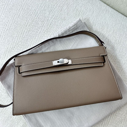 Gray split leather inspired Kelly Elan shoulder bag with silver hardware on a white dust bag.