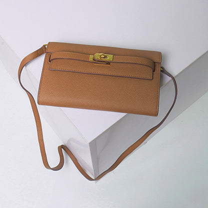 Front view of a tan inspired Kelly to go wallet in textured cowhide leather, featuring the iconic golden Kelli Closure and a slender leather strap.