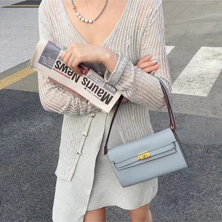 Front view of a Linen Blue inspired Kelly to go wallet in textured cowhide leather, showcasing the iconic golden Kelly closure and signature straps.