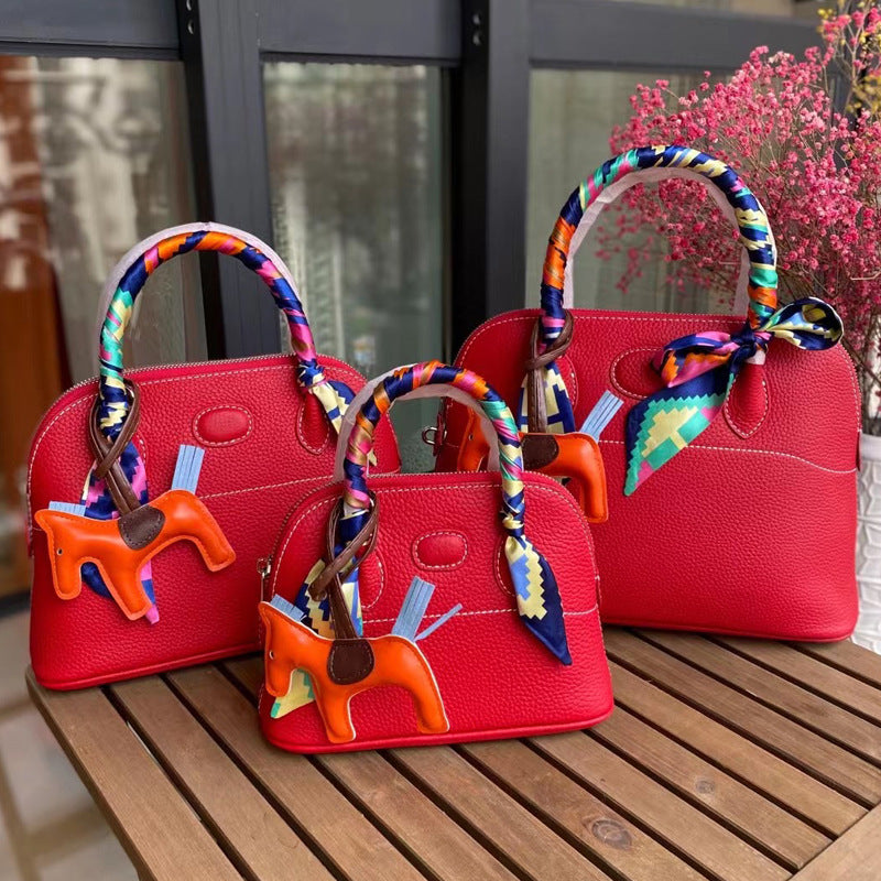 Three sizes of red leather bowling shell bags comparison with silk scarves