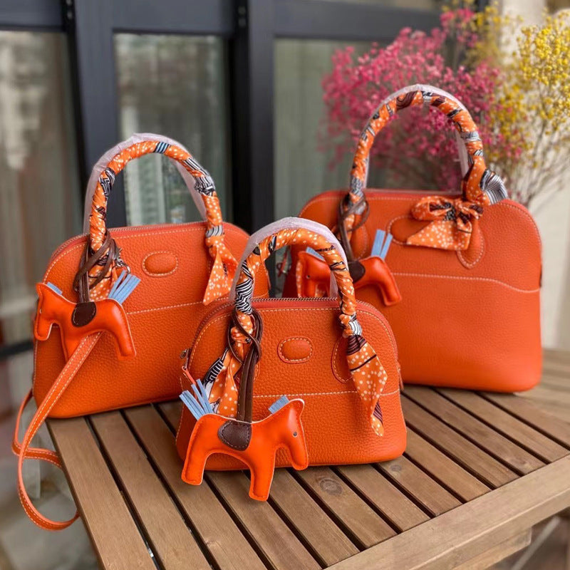 Three sizes of orange leather bowling shell bags comparison with silk scarves