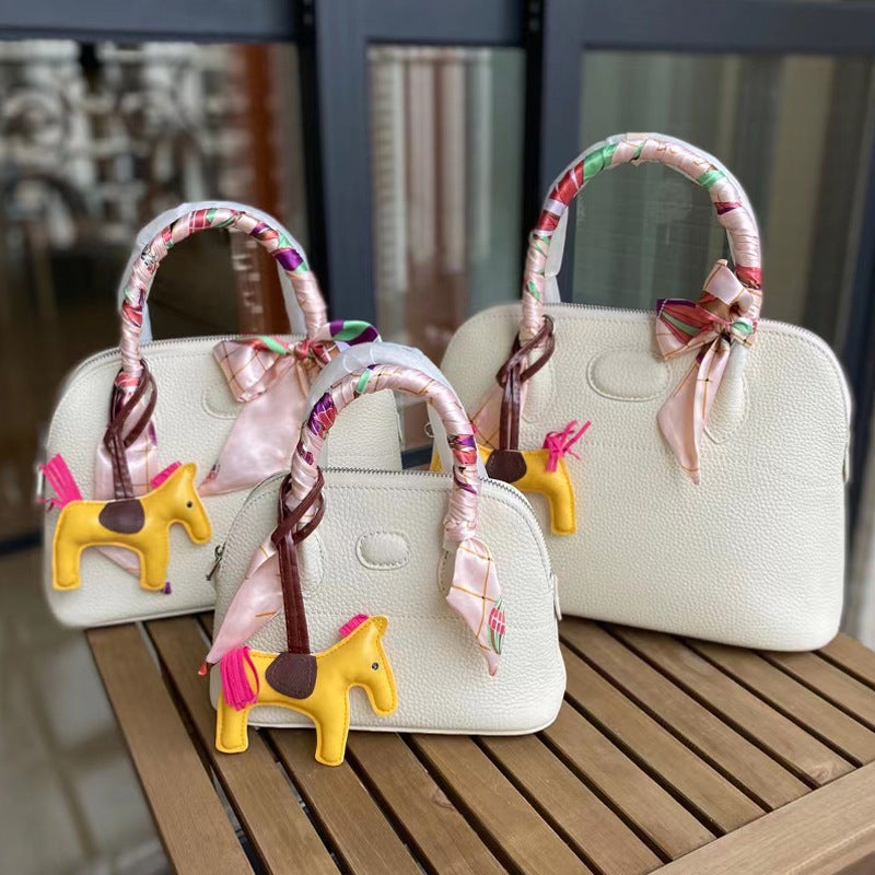 Three sizes of Pearly White leather bowling shell bags comparison with silk scarves