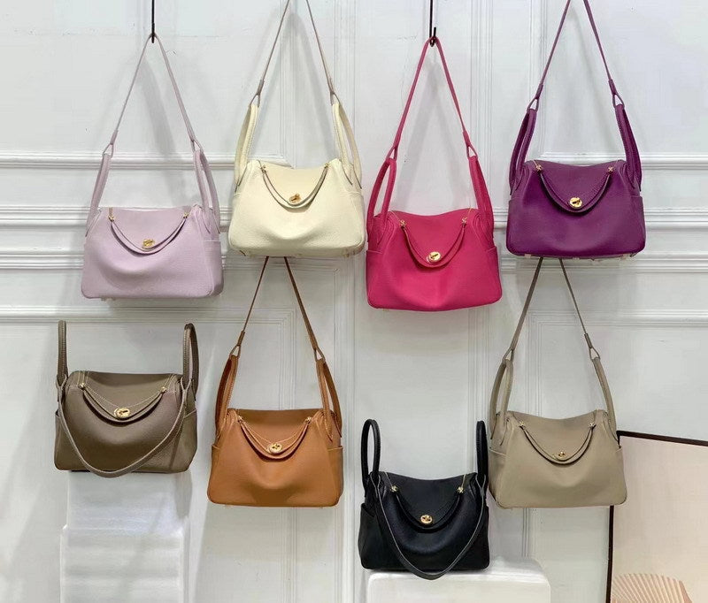 Group shot of top grain leather Lindy handbags with golden har.