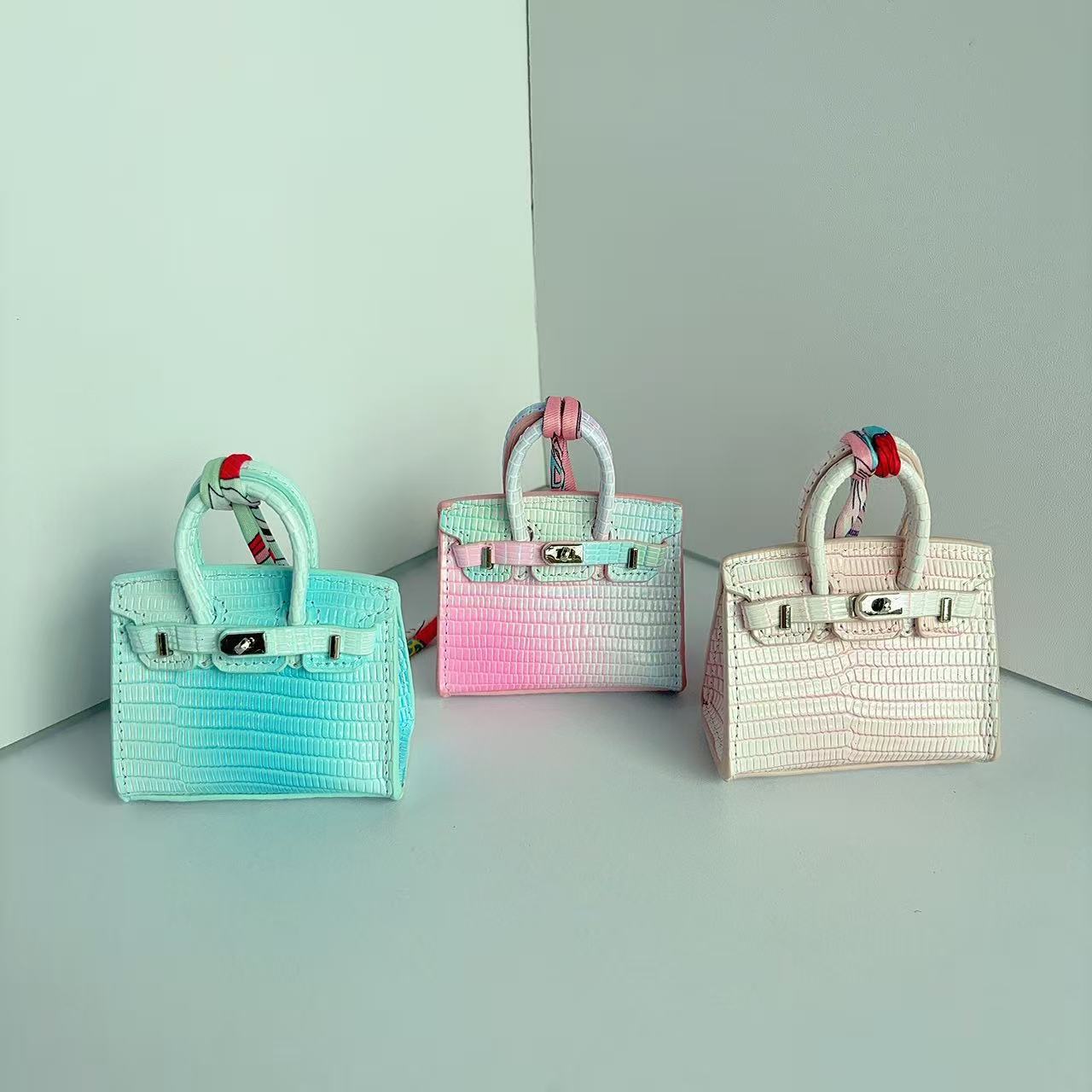 A series of colorful genuine leather mini "Birkin" bag charms, featuring crocodile-embossed textures and gradient color schemes.