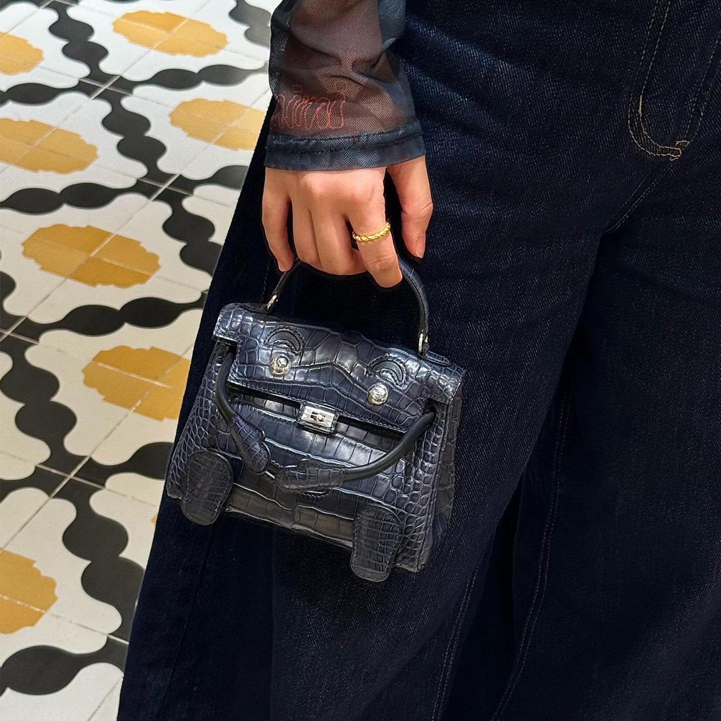 Micro croc-embossed leather doll bag with unique face design for a bold statement.