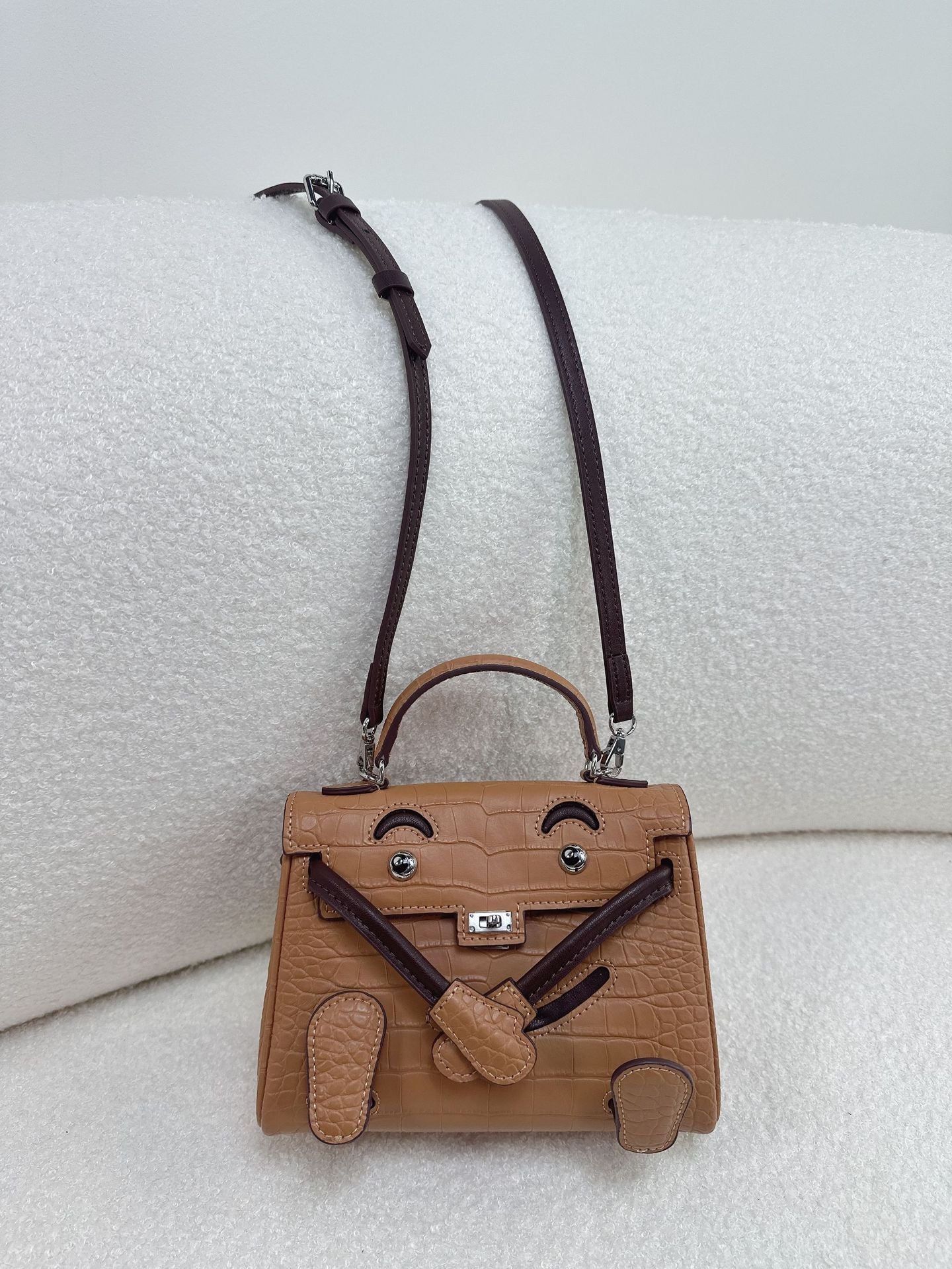 Premium brown leather doll bag with unique character design, perfect for versatile daily styling.