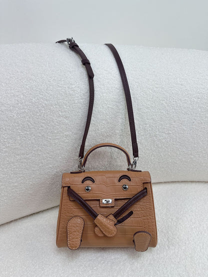 Premium brown leather doll bag with unique character design, perfect for versatile daily styling.