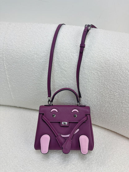  Unique purple and pink leather doll bag with adjustable strap for a trendy, artistic look.