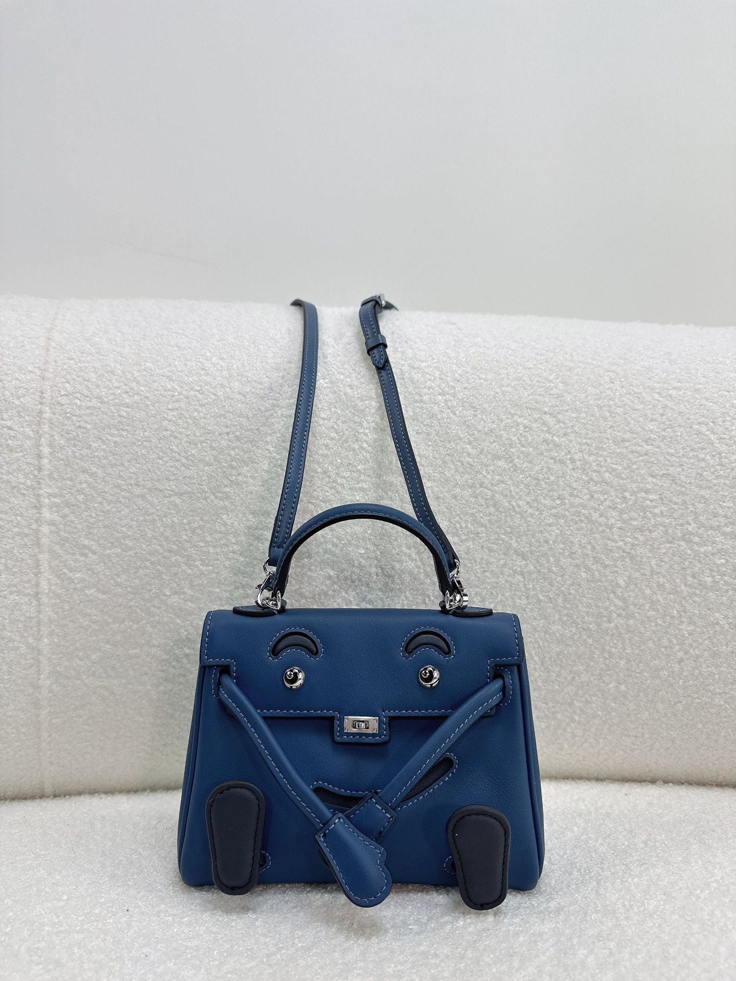Inspired Kelli Doll mini bag in deep blue smooth leather with navy blue accents and playful face.