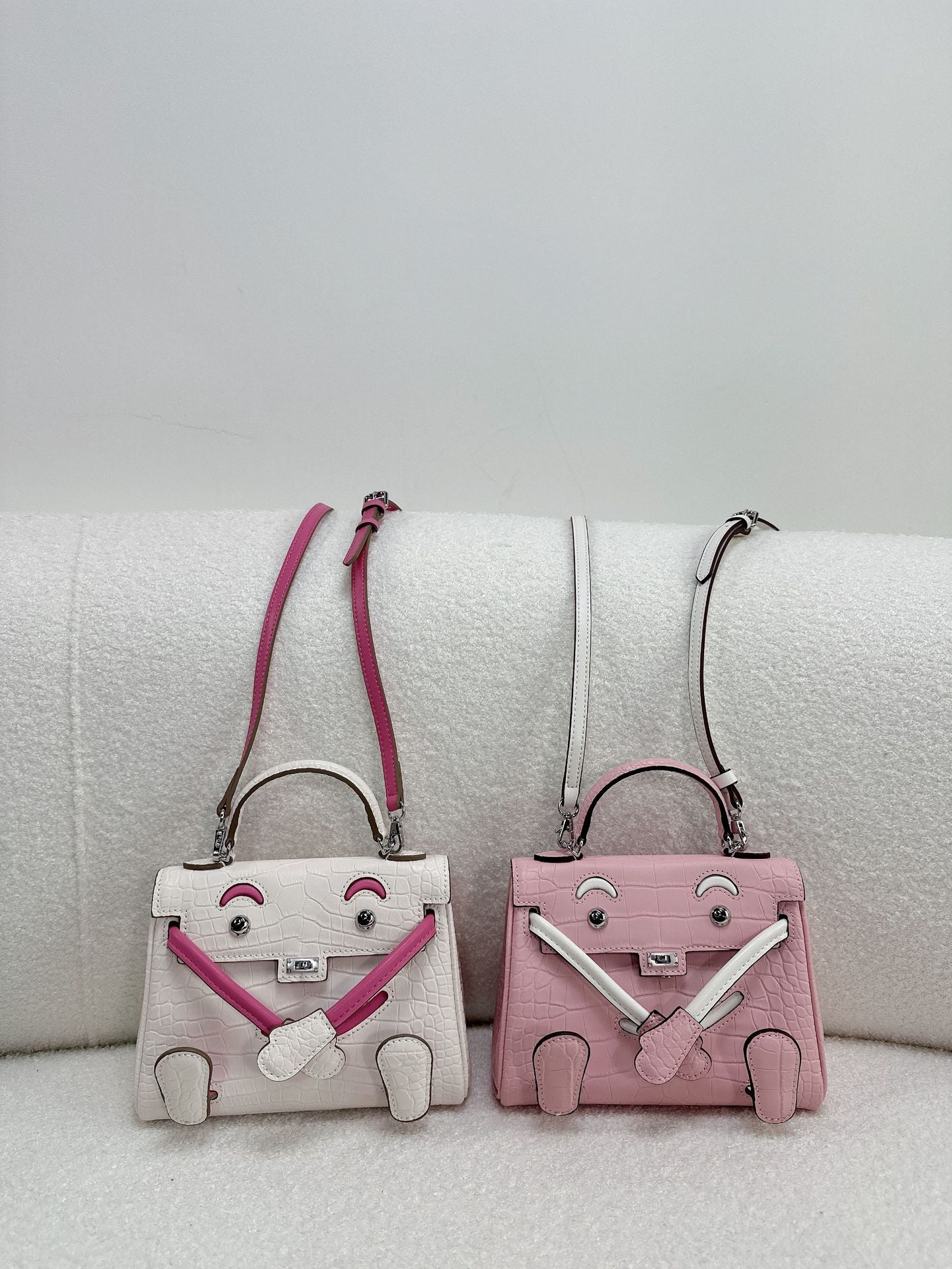  Chic croc-embossed leather Kelli Doll bags in vibrant pink and white colorways with adjustable straps.