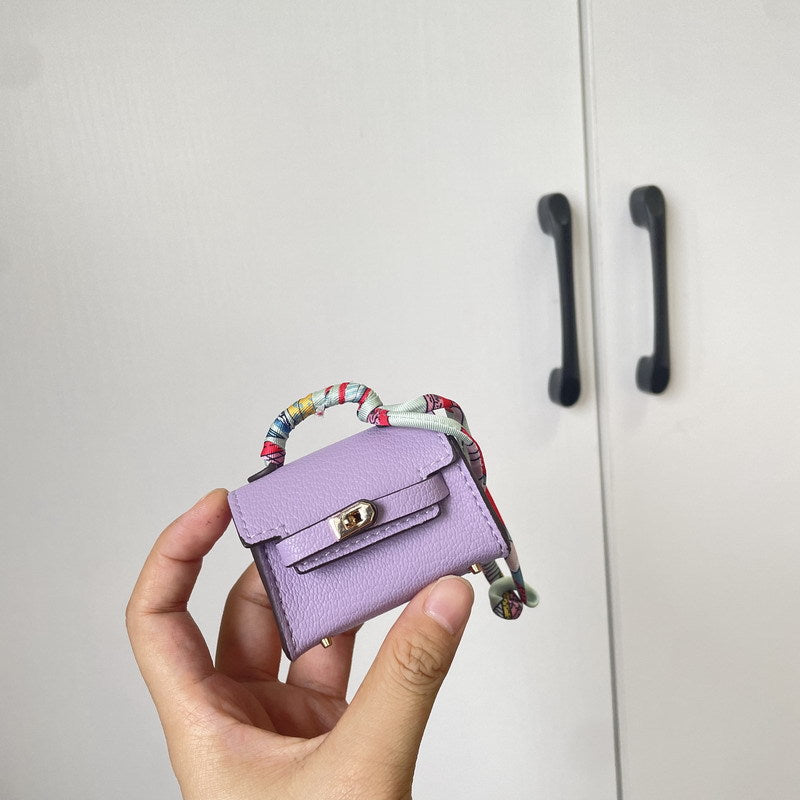 A light purple Mini Kelli bag charm, accented with a silk scarf detail.