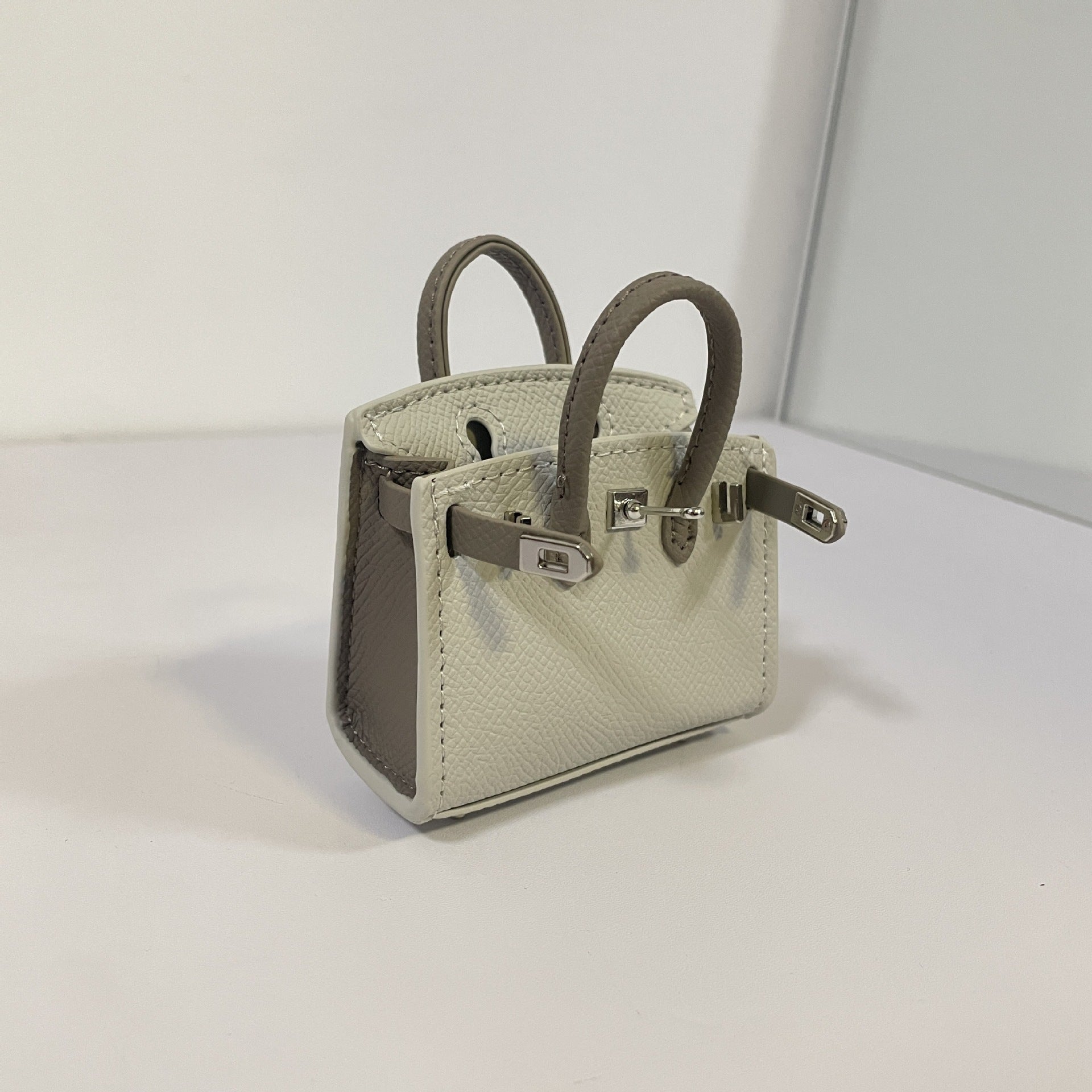 Two-tone gray and dark gray mini Birkin bag charm with silver hardware.