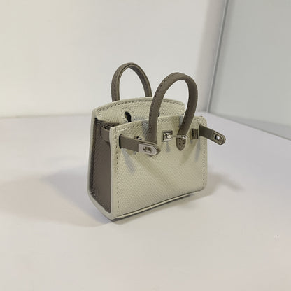 Two-tone gray and dark gray mini Birkin bag charm with silver hardware.