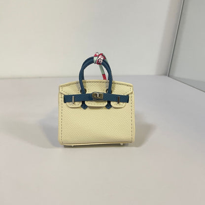 Two-tone off-white and dark blue mini Birkin bag charm with silk scarf handle.