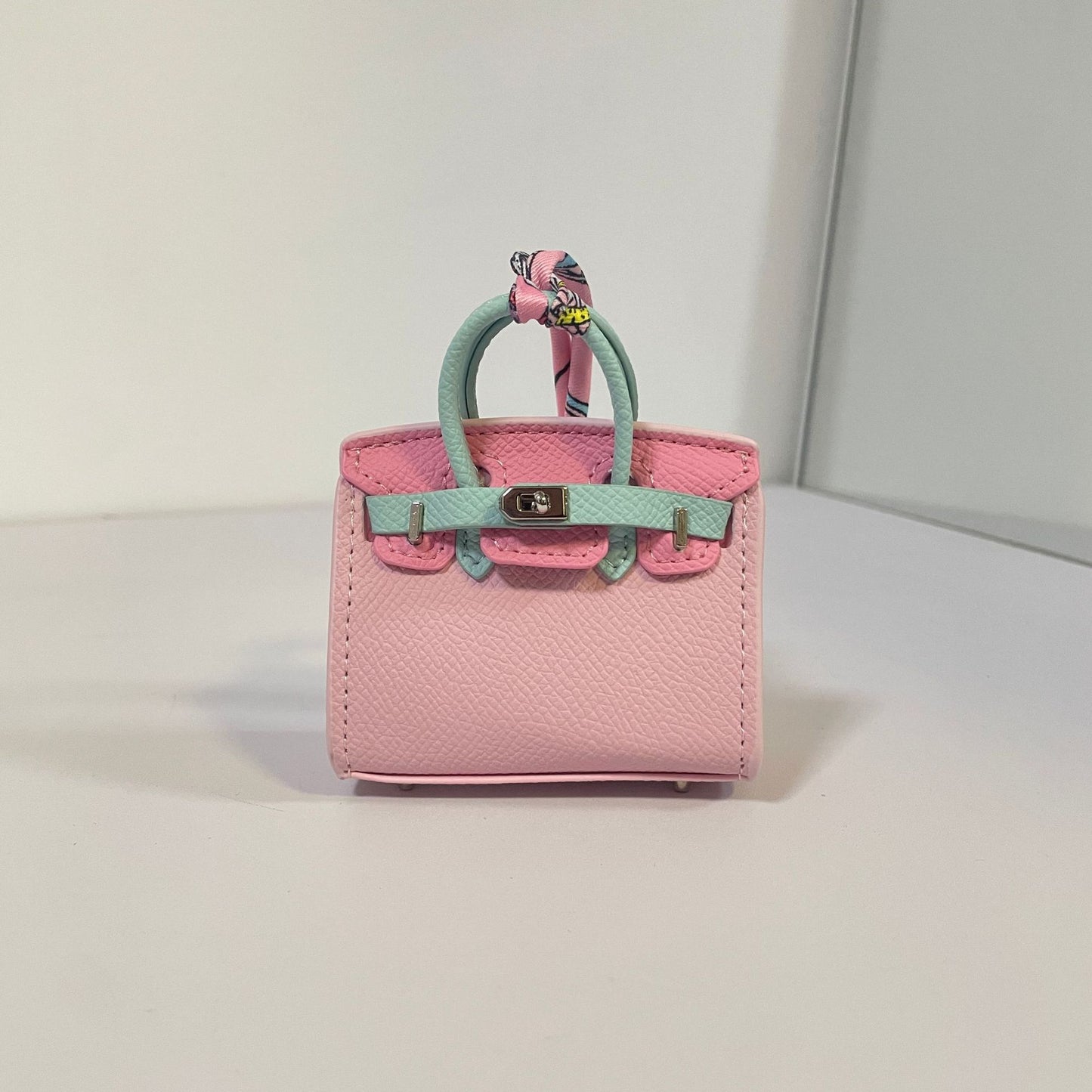 Two-tone pink and light blue mini Birkin bag charm with a pink silk scarf handle.