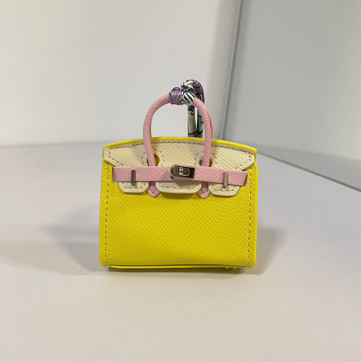 Tri-color yellow, off-white, and light pink mini Birkin bag charm with silk scarf handle.