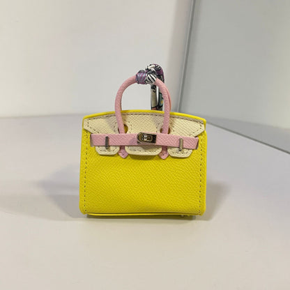 Tri-color yellow, off-white, and light pink mini Birkin bag charm with silk scarf handle.
