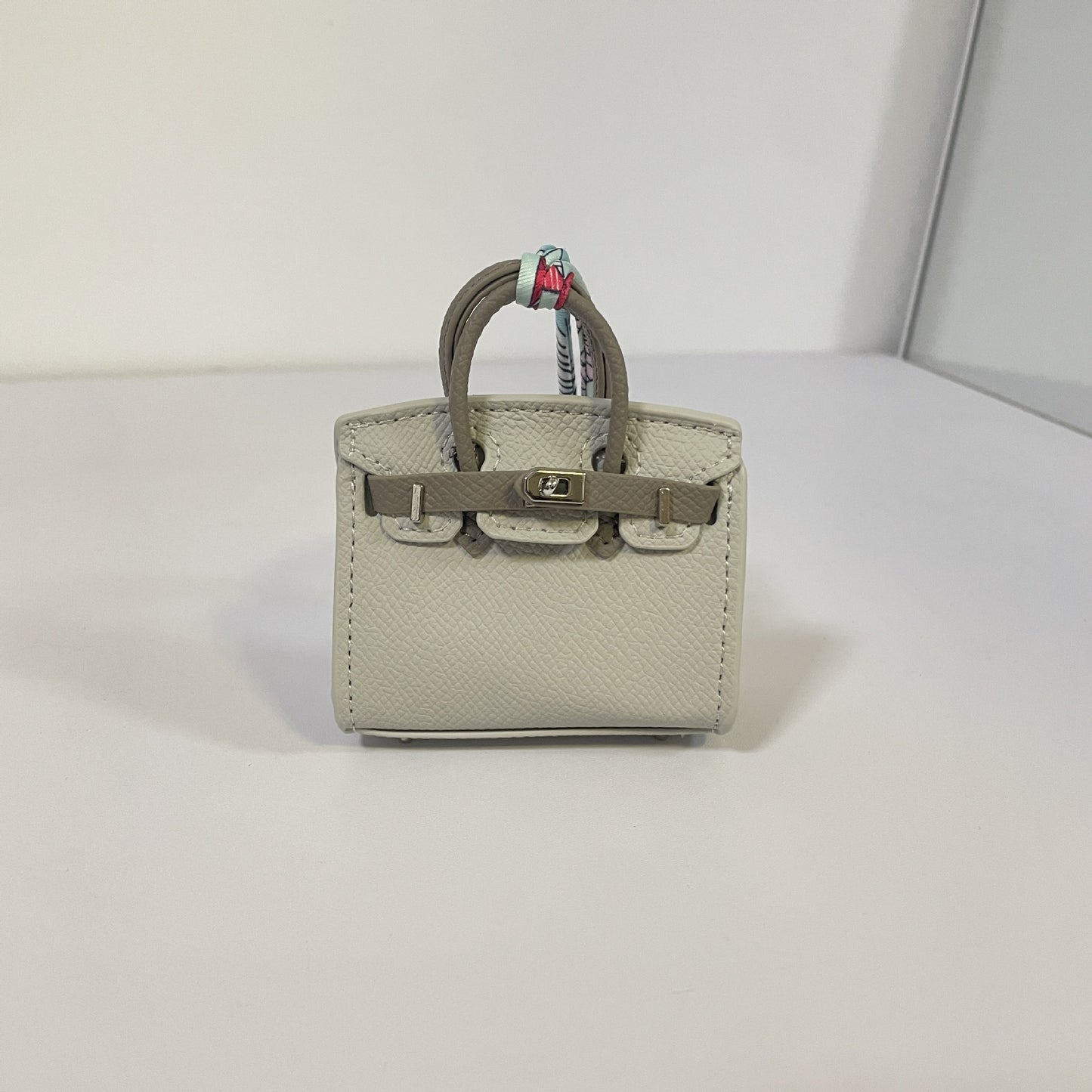 Two-tone gray and dark gray mini Birkin bag charm with silver hardware.