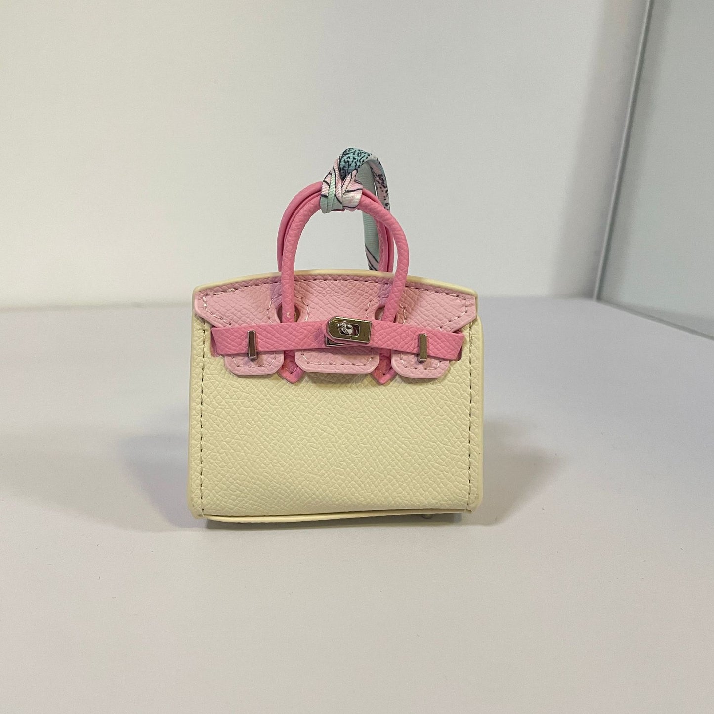 Tri-color off-white and pink mini Birkin bag charm with a floral silk scarf.