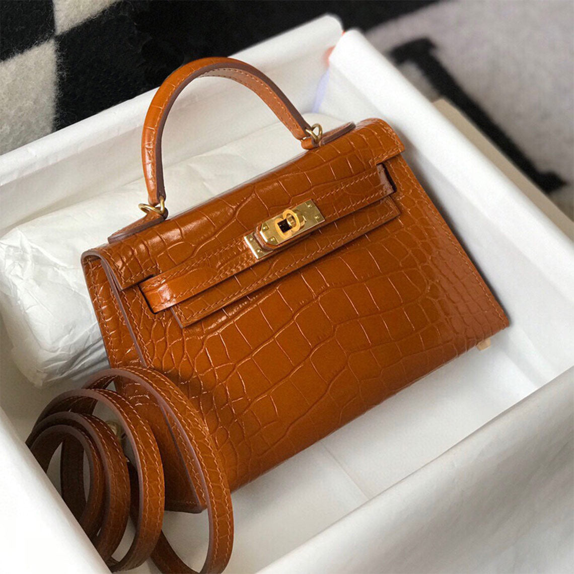 Gold Brown croc-embossed leather mini Kelly handbag inside a white packaging box with a matching leather shoulder strap.
