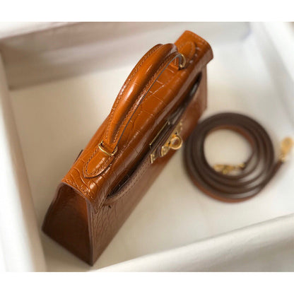 Top-down view of Gold Brown croc embossed leather mini Kelly handbag with sturdy handle and matching shoulder strap.
