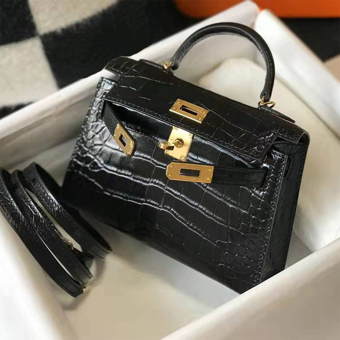 Black croc embossed leather mini Kelly handbag with iconic gold-tone lock and matching shoulder strap.
