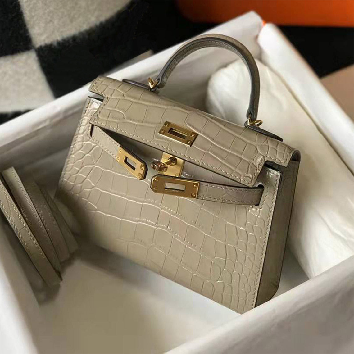 Khaki croc embossed leather mini Kelly bag with gold-tone lock and sturdy top handle in a white gift box.
