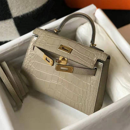 Khaki croc embossed leather mini Kelly bag with gold-tone lock and sturdy top handle in a white gift box.