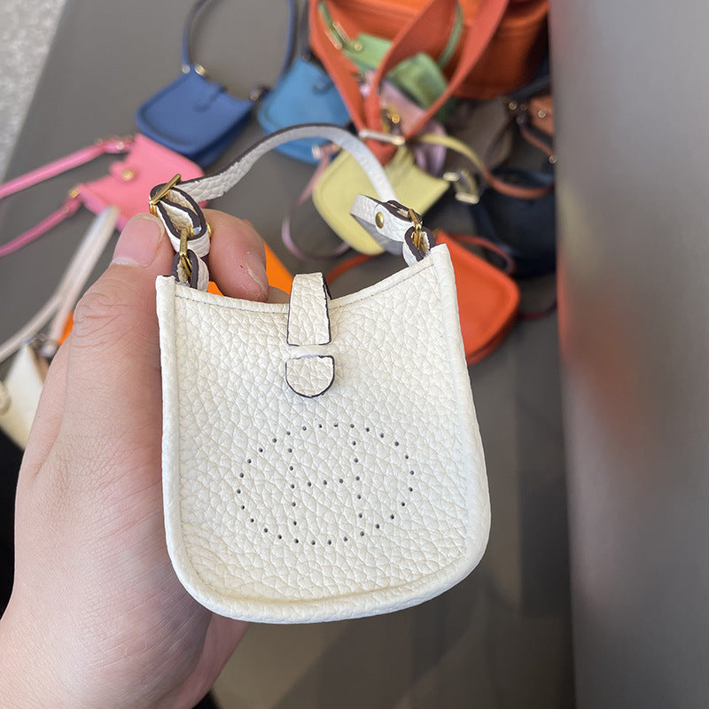 White mini leather Eveline bag charm AirPods Pro holder with H logo detail.