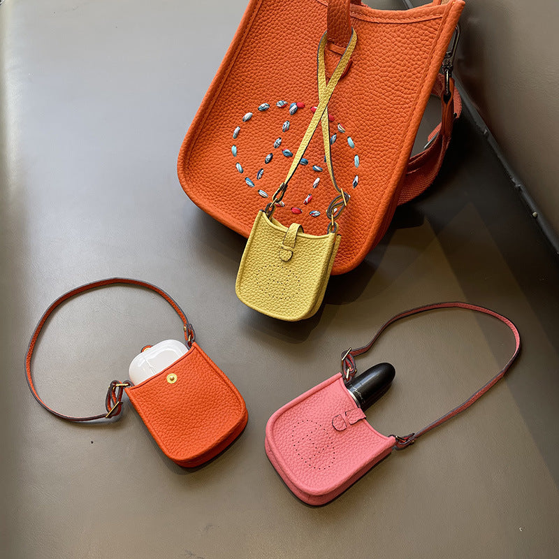 Mini Eveline leather bag charm showcasing AirPods and lipstick storage utility.