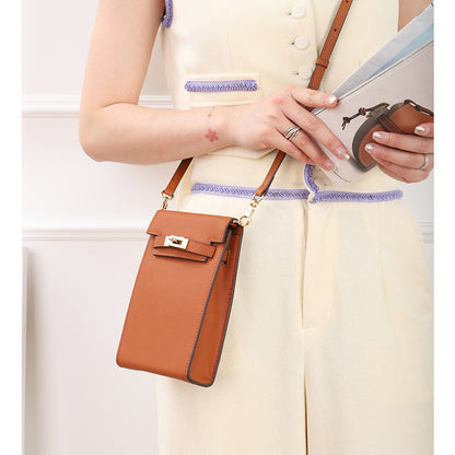 Model wearing a Gold Brown genuine leather mini phone bag with Kelly-style gold lock as a crossbody bag.