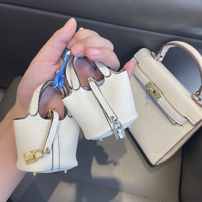 White mini leather Picotin bag charms with gold and silver lock details.