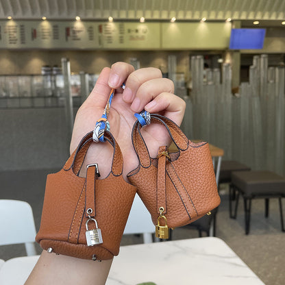 Brown mini leather Picotin bag charms with silk ribbon and lock detail.