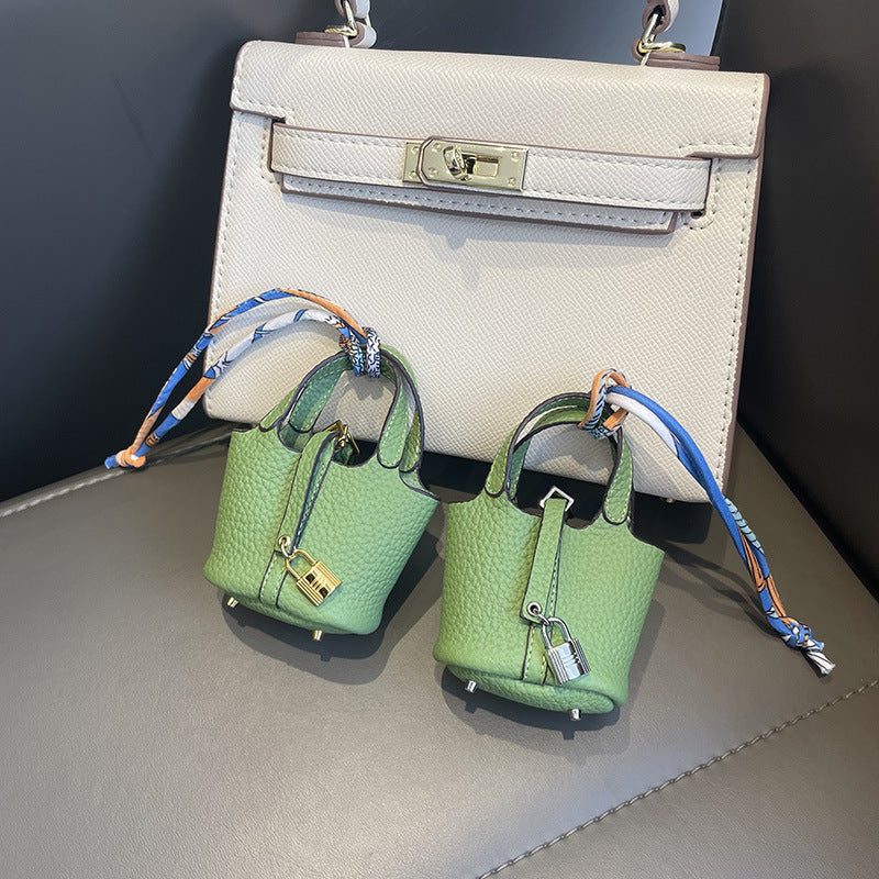Light Green mini leather Picotin bag charms with silk ribbon on white handbag.