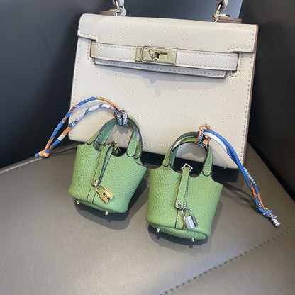 Light Green mini leather Picotin bag charms with silk ribbon on white handbag.