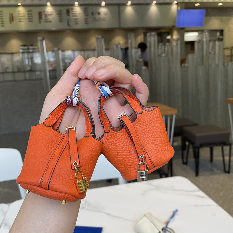 Orange mini leather Picotin bag charms with silk ribbon and lock detail.