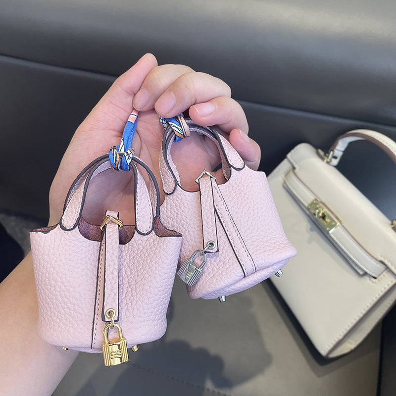 Light pink mini leather Picotin bag charms with silk ribbon and lock detail.