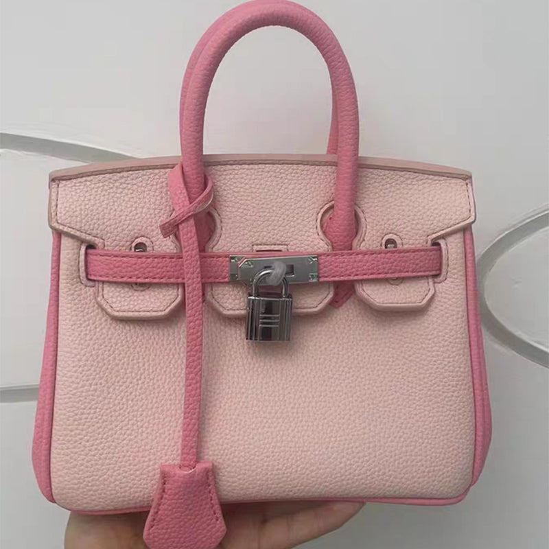 Front view of a bi-color Pink and Rose Pink inspired Birkin handbag in textured cow split leather, featuring a silver padlock and signature double rolled handles.