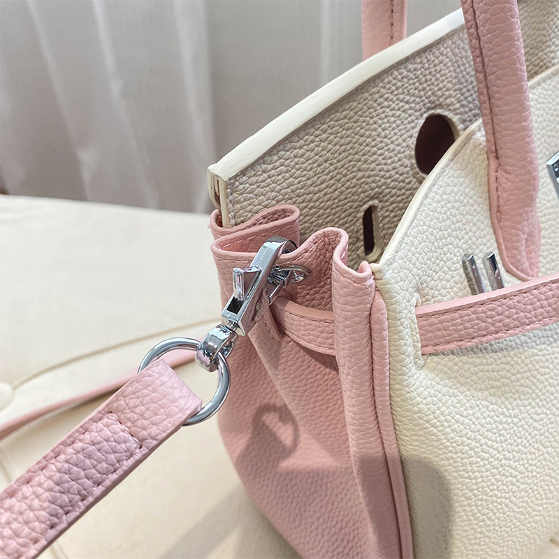 Close-up of the bi-color Pink and White inspired Birkin handbag, showcasing the textured top grain leather and high-quality silver hardware swivel clasp on the detachable shoulder strap.