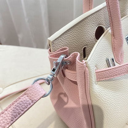 Close-up of the bi-color Pink and White inspired Birkin handbag, showcasing the textured top grain leather and high-quality silver hardware swivel clasp on the detachable shoulder strap.